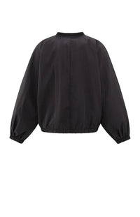 A women's lightweight bomber jacket in a soft beige color with a relaxed, slightly oversized fit. It features a round neckline, a full-length front zipper, and gathered detailing along the chest for a subtle textured effect. The long sleeves are voluminous and taper into elasticated cuffs, while the hem also has an elastic finish for a comfortable and slightly cropped silhouette.
