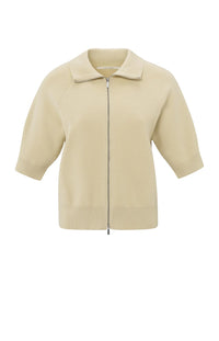 his is a women's short-sleeve zip-up cardigan in a soft, warm beige color. It is made from a finely knitted fabric with a smooth texture and a structured yet comfortable fit. The cardigan features a classic folded collar that sits neatly around the neckline, leading down to a silver-toned full-length zipper at the front, allowing it to be worn open or closed.

The sleeves are elbow-length with a slightly loose fit, finished with ribbed cuffs for a subtle contrast in texture. The hem is also ribbed, giving t