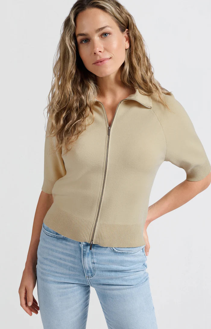 his is a women's short-sleeve zip-up cardigan in a soft, warm beige color. It is made from a finely knitted fabric with a smooth texture and a structured yet comfortable fit. The cardigan features a classic folded collar that sits neatly around the neckline, leading down to a silver-toned full-length zipper at the front, allowing it to be worn open or closed.

The sleeves are elbow-length with a slightly loose fit, finished with ribbed cuffs for a subtle contrast in texture. The hem is also ribbed, giving t
